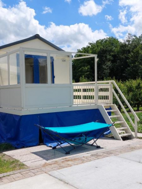 Voormalig strandhuisje in boomgaard in Hengstdijk